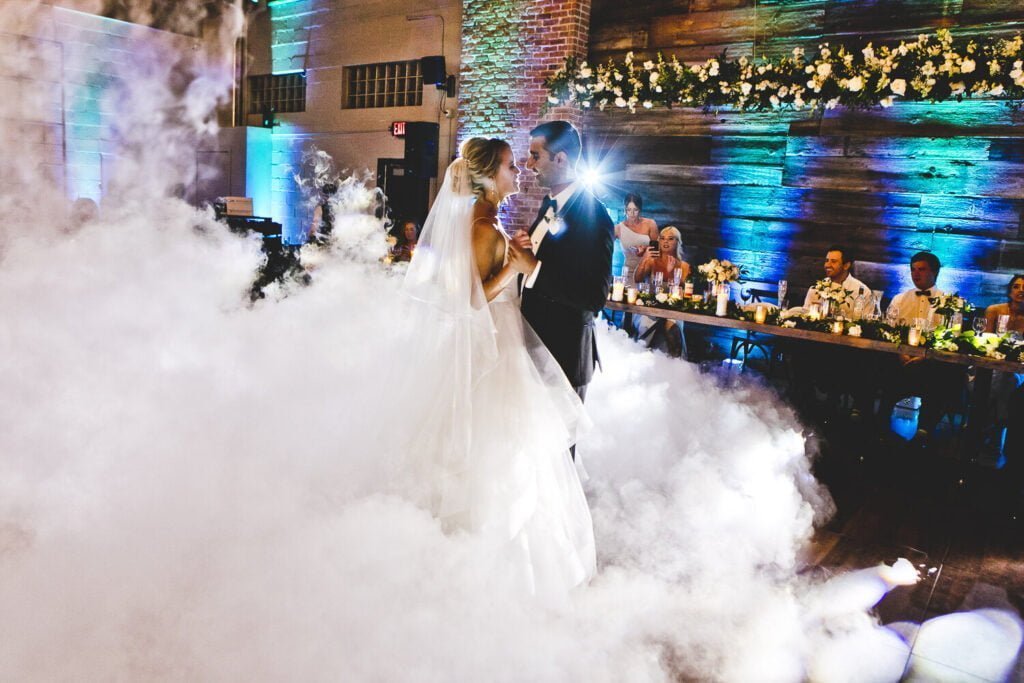 Bride and groom dancing amongst a smoke machine and twinkling lights